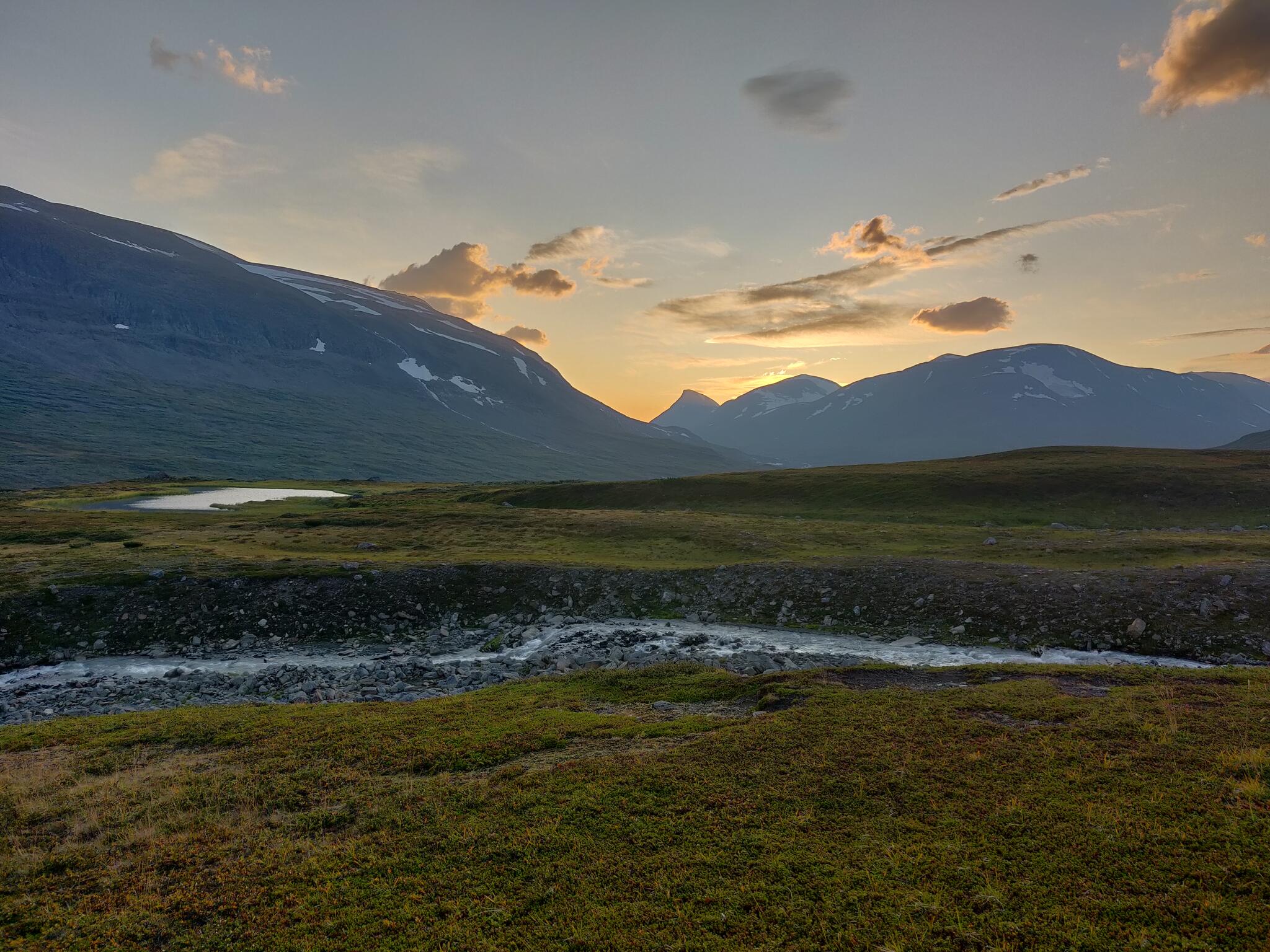 The sunset over Ruohtes from the shores of Tjaggnarisjahka.  The distinctive peak in the distance must be Guohper.