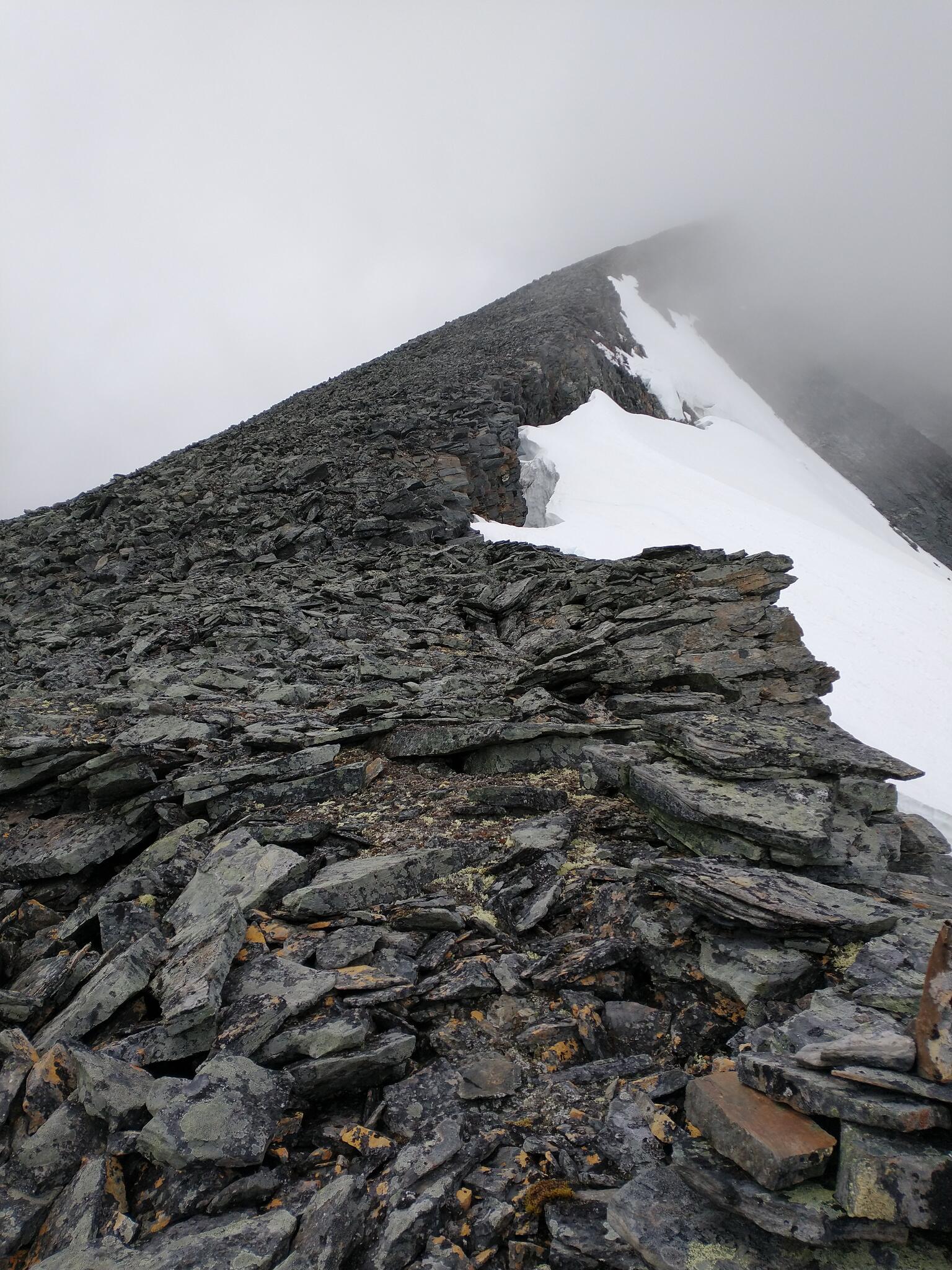 Upp mot Šielmmáčohkkas stortopp. Siehtagasglaciären klättrar högt upp längs bergsväggen. 