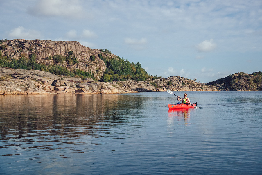 Foto: Melanie Haas En paddlare i en röd kajak på stilla vatten.