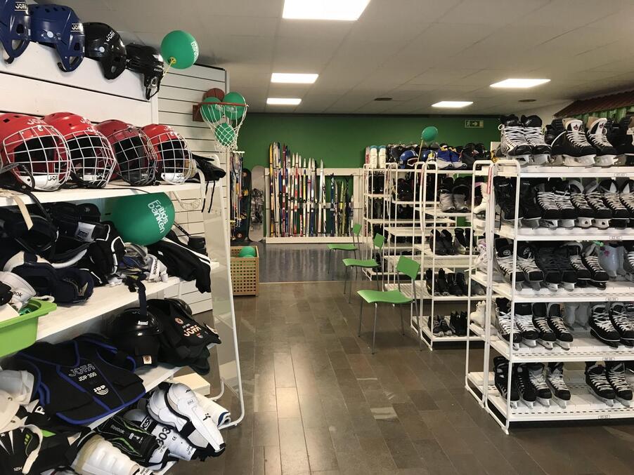 En lokal med hyllor fyllda av skridskor, skidor med mera.