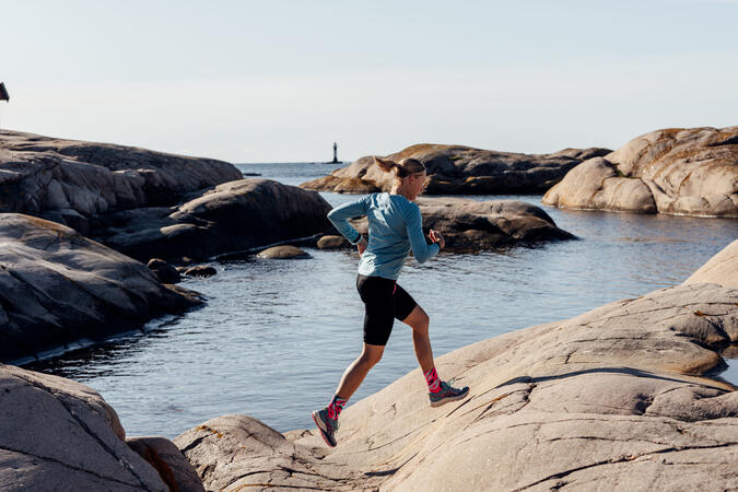 Foto: Bohusläns Bästa En kvinna springer på klippor. I bakgrunden syns havet.