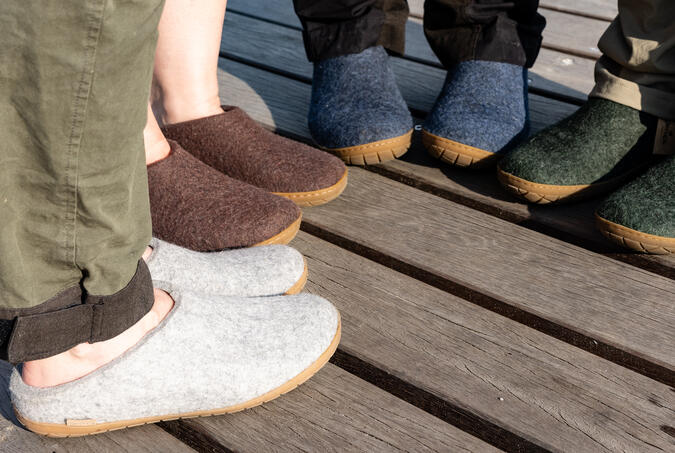 Foto: Piotr Fyra personers fötter, som bär toffeln "Slip-on with Natural rubber sole" från Glerups.
