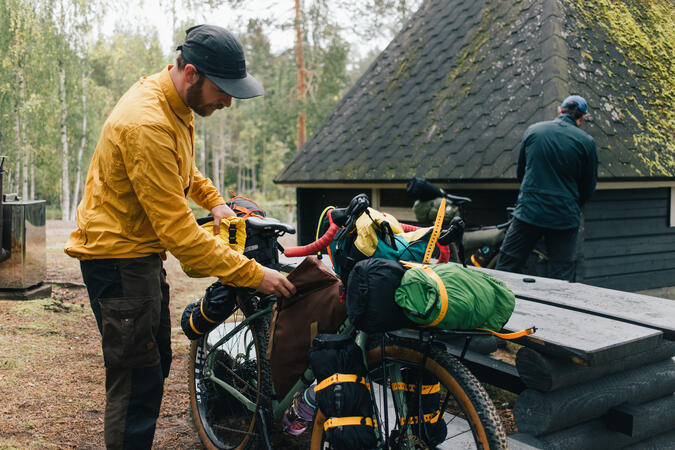 En man ordnar med packningen på sin gravelbike.