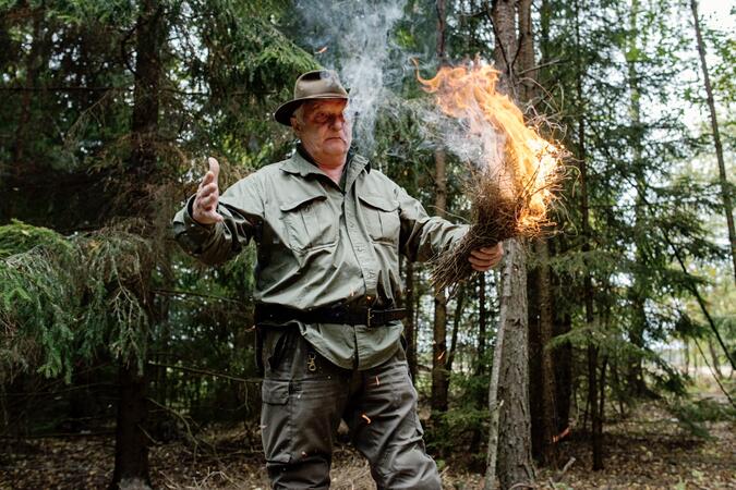 Författaren Lars Fält, med ett knippe brinnande ris i handen.