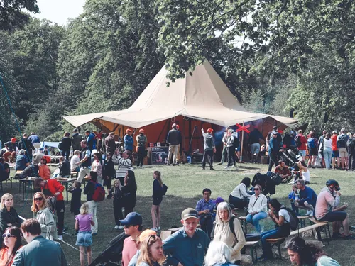 En stor tältkåta med många människor samlade runt