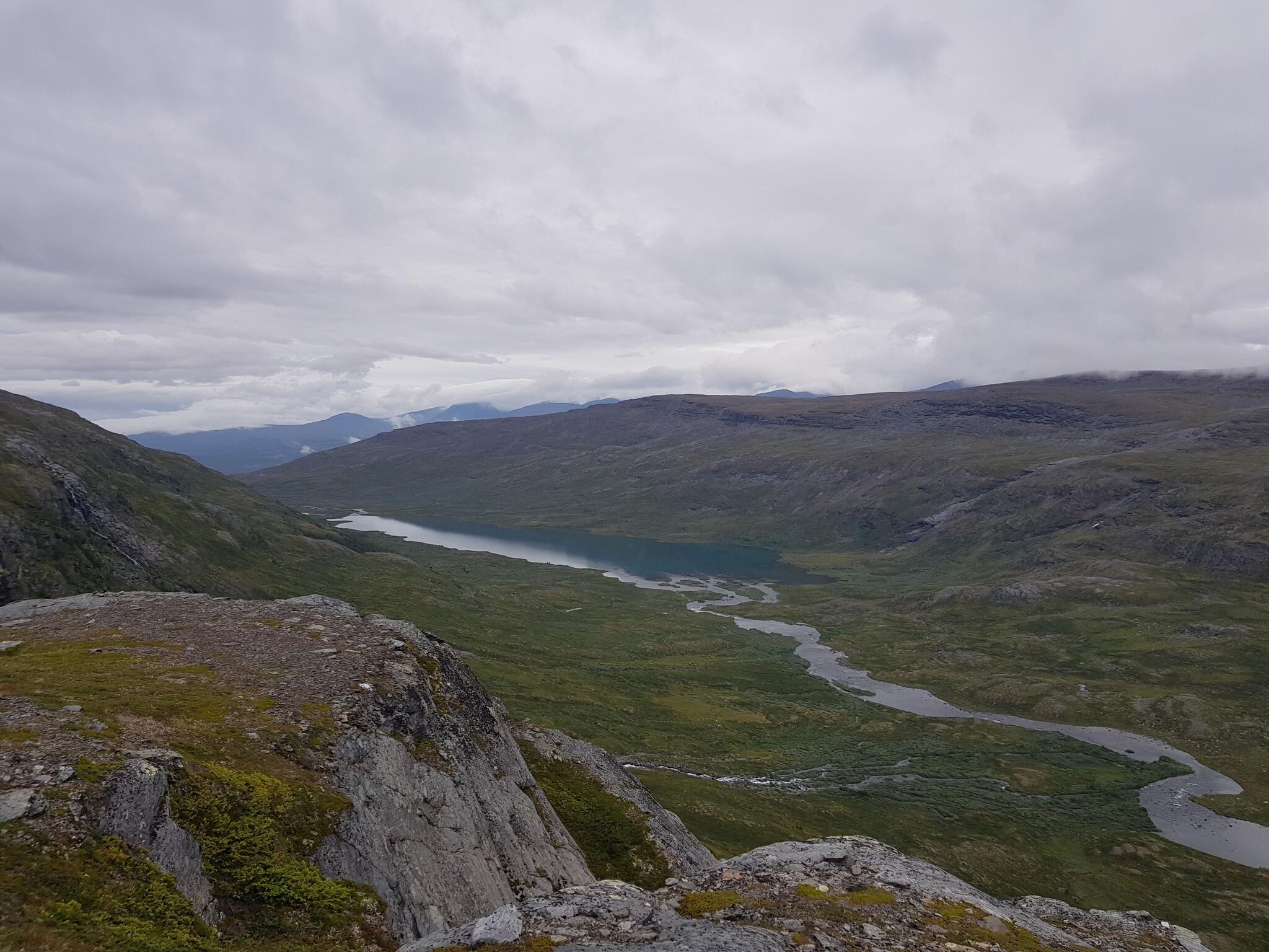 Utsikt över Östra Kårsavagge och Vuolimus Gorsajávrit. I bildens nederkant, i mitten, skymtar man avrinningsdeltat från Latnjajávrit som man måste korsa för att ni Kårsavaggestugan österifrån.